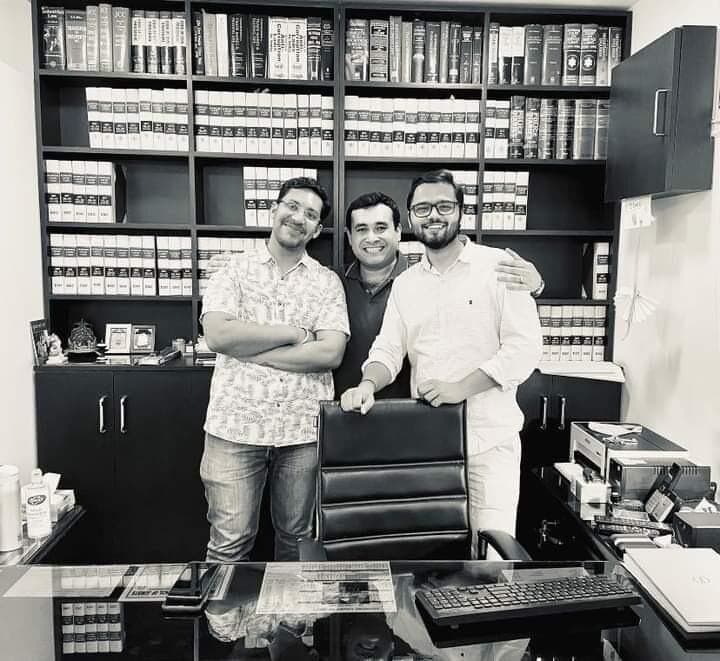 Three men in a chamber lined with law books